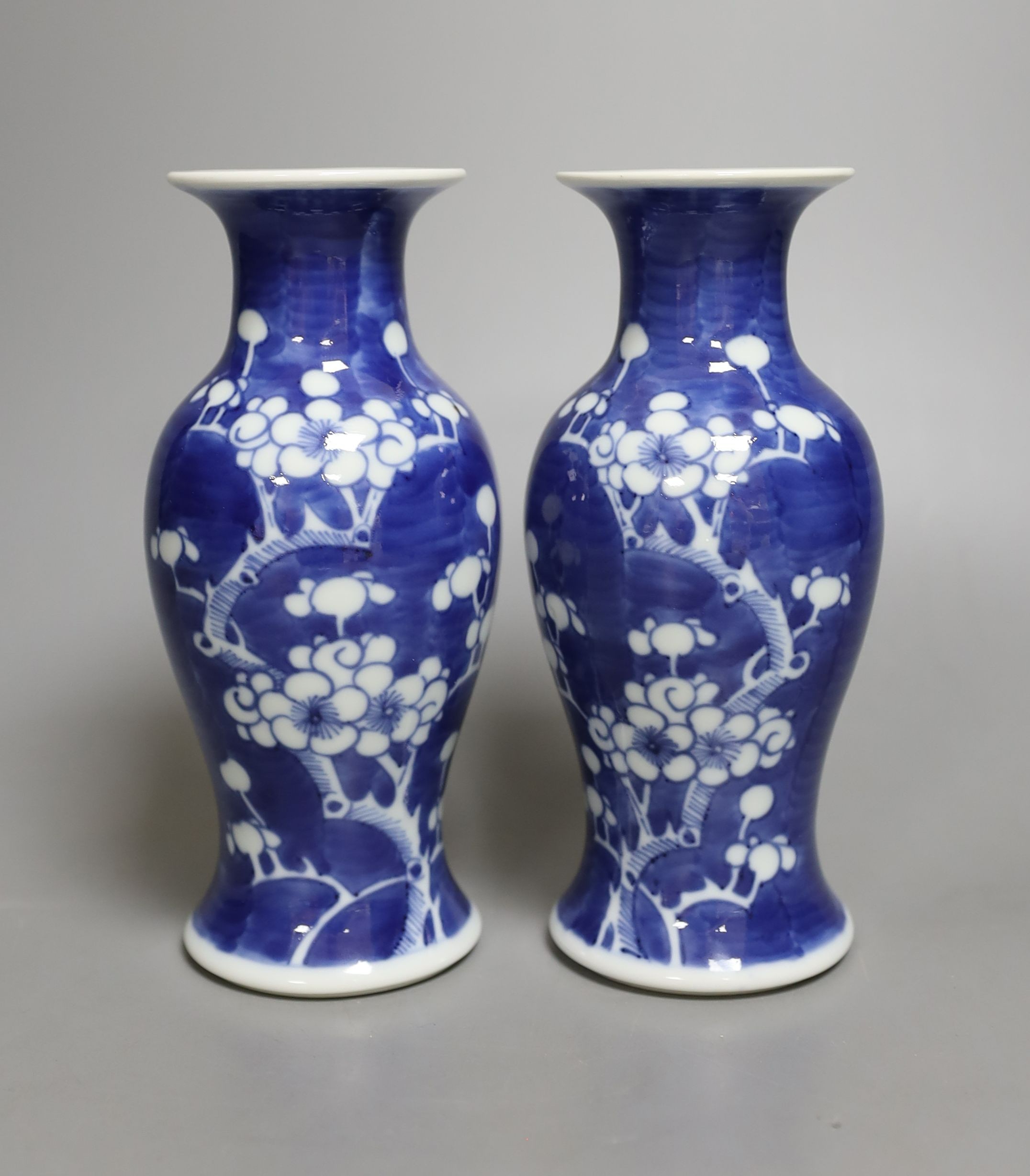 A pair of early 20th century Chinese prunus blue and white baluster form vases, 16 cms high.